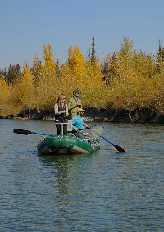 Three people are in a small boat fishing on clear water.