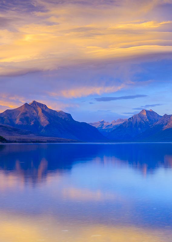 A view of a blue lake with mountains rising in the distance.