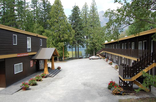 Motel Lake McDonald nestled between tall coniferous and deciduous trees.