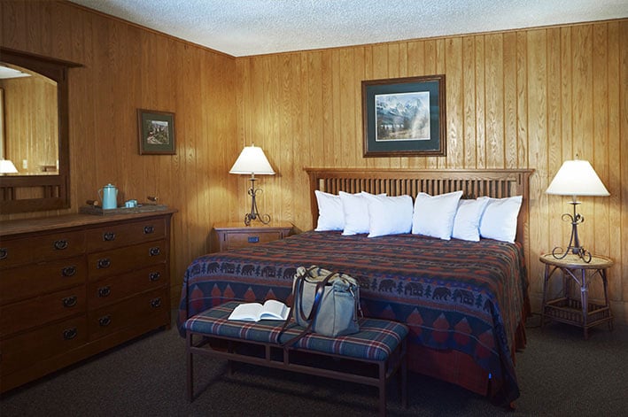 Bedroom with one king bed in a Glacier Park Lodge suite