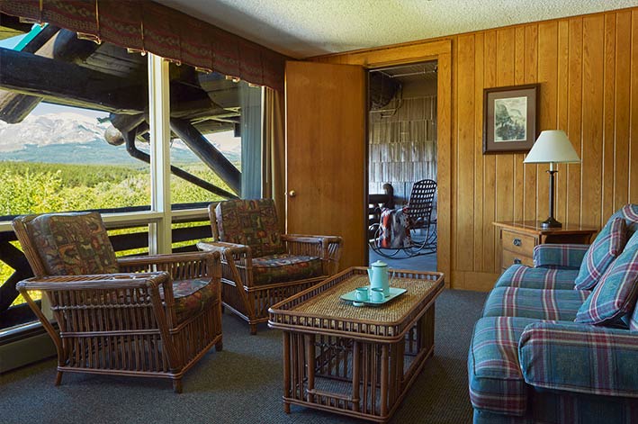 Spacious sitting area and adjacent private balcony in a suite in Glacier Park Lodge