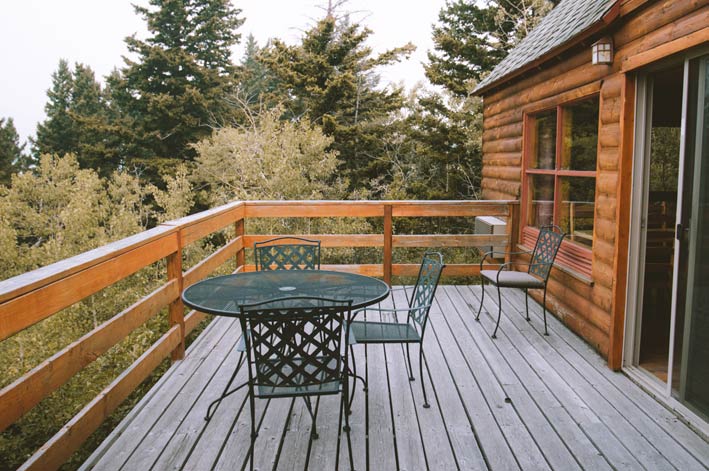 A wooden porch alongside a log cabin.