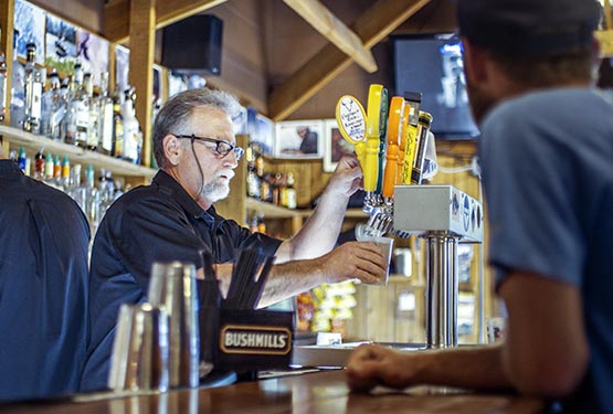 A bartender pours beer.