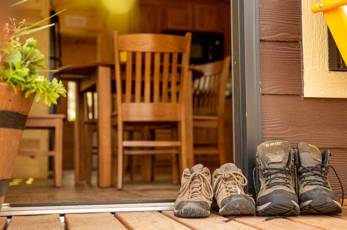 Two pairs of hiking boots on a wooden porch