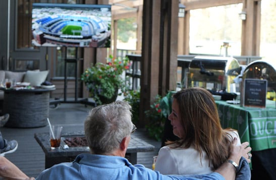 A couple watching the football game on a restaurant patio