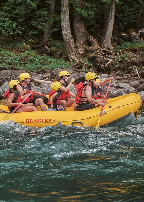 A group of rafters paddle down a river.