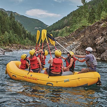 Rafters cheer with their paddles on the water.