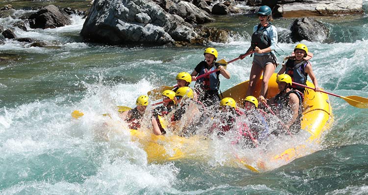 A group of rafters make a splash along a river.