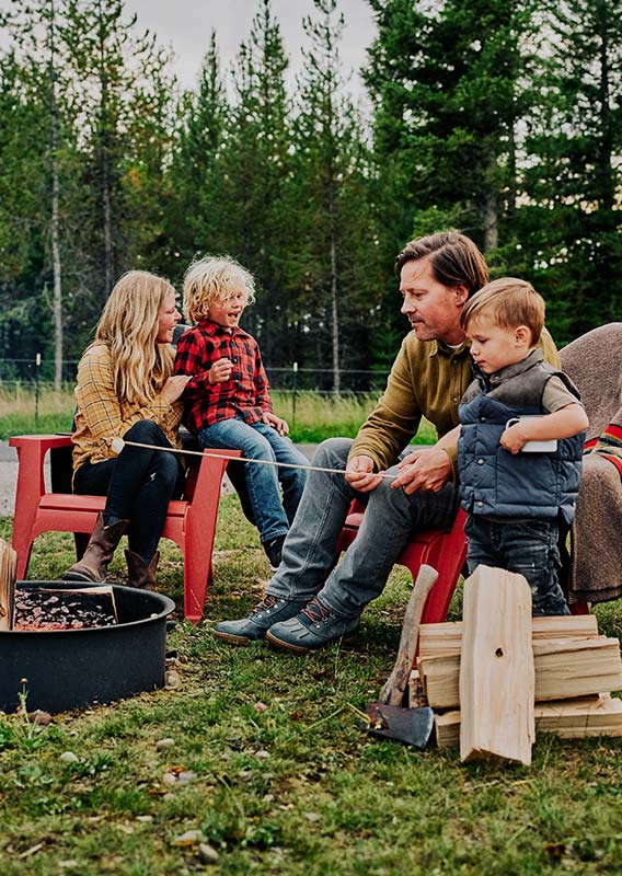 A family sitting at a campfire in a campground