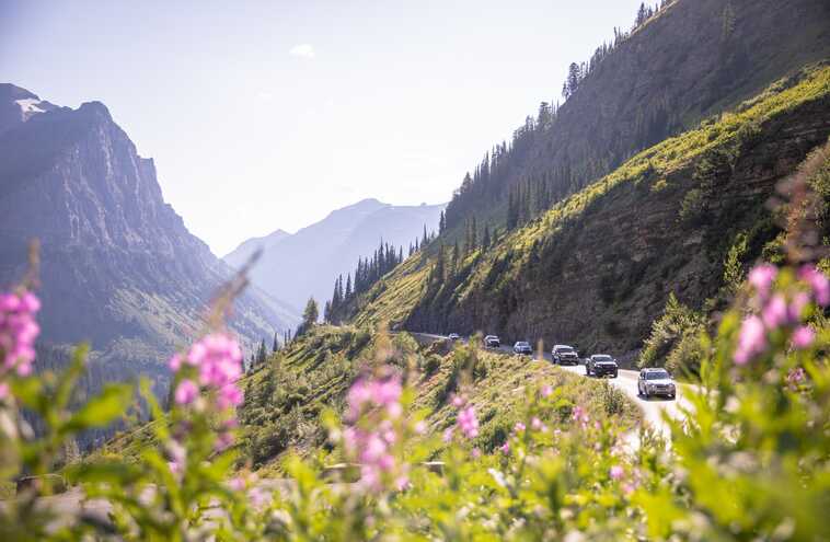 Cars driving along Going-to-the-Sun Road with mountain view
